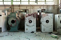 Industrial washers and dryers covered in red paint in an abandoned hospital. Ontario, Canada.