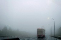 A truck drives in heavy, dripping fog on a highway, Nova Scotia.