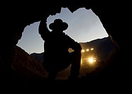 Man looking inside mine entrance, Mojave Desert, California, USA