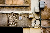 A doorway with crest, wiring and junction boxes (telephone and electricity) in Sepulveda, Segovia, Castilla-Leon, Spain