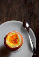 Soft boiled egg in egg cup on wooden background.