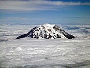 Mt. Rainier above the clouds. Rainier is the tallest mountain in th state of Washington about 55 miles southeast of Seattle. Mt. Rainier´s peak is 14,...