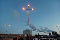 Street lamps on in a parking lot at dusk, with Grozavesti Power Station in the background - Bucharest, Romania, Europe, Eastern Europe.