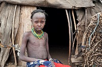 Girl belonging to the Dhasanech tribe in front of a hut ( Omo valley, Ethiopia).