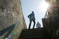 Stair at the entrance of the City Wall of Lugo, Galicia, Spain. Back lit image showing two people and a twinkle of the sun