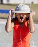 A little girl playing in the water at a water park.