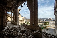 Ruined corridor of Darul Aman Palace during Mujahideen factions fought for control of Kabul in the early 1990s and building of new parliament on backg...