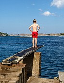 Kid jumps to the sea, Fjallbacka, bohuslan region, west coast, Sweden.