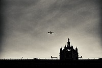 View of a dome of the Victoria and Albert Museum with an airplane flying in the sky. South Kensington, London, England, UK