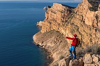 Hiker takes Gopro video over the Mediterranean sea from Sierra Helada natural park cliff, Benidorm, Alicante province, Spain.
