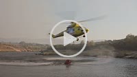 Several helicopters approach each one to a reservoir to fill the water tank and extinguish a forest fire in the southern region of Galicia