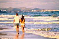 Couple on the beach walking back. Costa Daurada, Costa Dorada, Catalonia, Spain.
