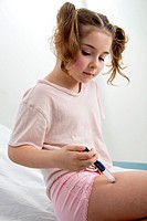 Little girl with bunches suffering from diabetes injecting herself insulin