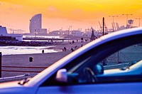 Beach at sunset. First, detail of a blurred car. In the background, beach and Hotel W by Ricardo Bofill architect. Hotel W, aka Vela Hotel, highlighti...