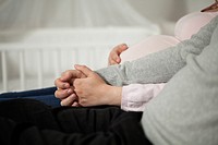 Pregnant woman and husband holding hands.