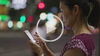 Women using her smart phone at night in Tokyo, Japan