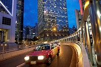 dusk traffic on curved, elevated roadway in the Admiralty district, with sections of Bank of China Tower and Chung Kong Centre buildings, Hong Kong.