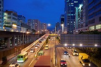 busy motorway and apartments at dusk in Kowloon Bay, China.