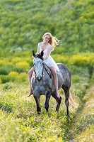 Girl riding a grey horse.