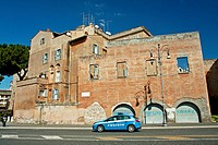 Police car passing by a building at Via dei Fori Imperiali in Rome, Italy