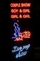 Neon lights of the Sex Palace porn shop and sex show theatre showing a couple having sex in a live peep show in the Red Light District famous for pros...
