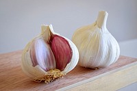 Garlic. Two garlics on a wooden surface.