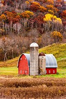 Red barn in colorful autumn valley.