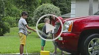Single mother washing car at home with her two children in driveway with hose MR-11, MR-12, MR-13 Model Released