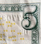 Closeup of the corner of an American $5 bill