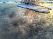 Steam rising from Lake Harriet in Minneapolis Minnesota USA on a very cold winter morning.