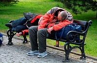Two homeless persons sleep on a bench in Swinoujscie; Western Pomerania, Poland.
