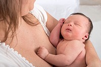 Baby 2 weeks old in mother´s arms, asleep after being breast feeded
