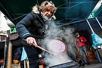 A woman observed how your railway pot (meat and potato stew is done over charcoal) in the competition for the festival of San Sebastian in Reinosa (Ca...