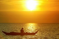 Fisherman in small boat sunrise Lake Tonle Sap near Siem Reap Cambodia.