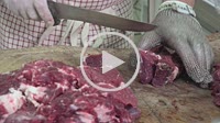 a butcher cutting meat cubes