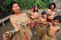 Yagua tribe located near Iquitos, Amazonian, Peru. Village women exhibit their pets: an alligator, an anaconda and a tiny pygmy marmoset (the smallest...