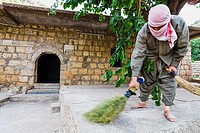 A Yezidi volunteer helps cleaning on the Lalish temples after Wednesday celebrations. Wednesday is the holy day for the practitioners of the Yezidi fa...
