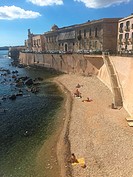 People sunbathing at the small beach, Ortigia island, Syracuse, Sicily, Italy, Europe