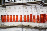 Red candles lit inside church, religion.