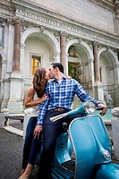 Couple kissing while sitting on a vespa scooter. Janiculum water fountain. Rome, Italy.