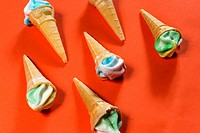 Sugar candy cones on an orange background, topped with frosted candy.