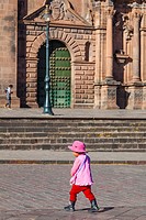 Young Peruvian child walking across the road in the Plaza de Armas, Cusco, Peru.
