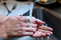 Woman´s hands being washed over a sink.
