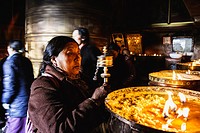 Old Tibetan woman swinging prayer wheels at Mani Lhakhang chapel, Lhasa, Tibet.
