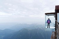 Woman in a crystal box on the void, Pas dans le Vide - step into the void - at 3842 m, Aiguille du Midi, Chamonix-Mont-Blanc, Haute-Savoie, France, Eu...