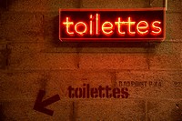 Arty original toilettes restrooms indication in red neon light