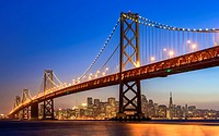 The Bay Bridge and San Francisco skyline at dusk.