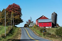 Country road and red barn, Oneida County, New York, USA.