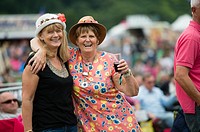 Two happy smiling laughing adult women enjoying the The Big Tribute Music festival, Aberystwyth, August Bank Holiday weekend, Summer 2015.