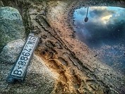 Abandoned car license plate and reflection in puddle. Arenys de Mar, Maresme, Barcelona province, Catalonia, Spain